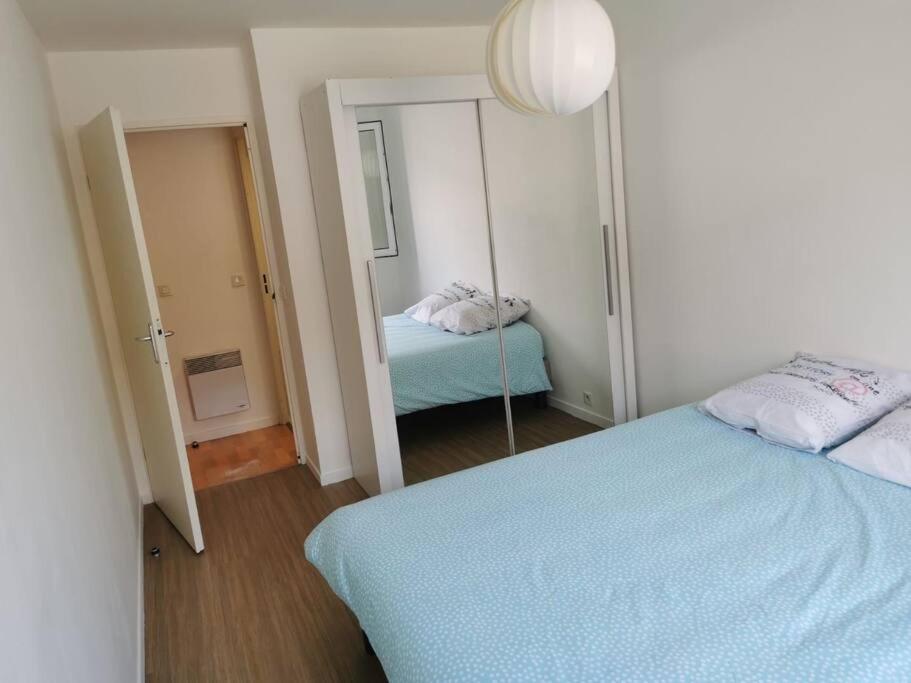 勒阿弗尔Plage du Havre的一间带镜子的卧室和一张床铺