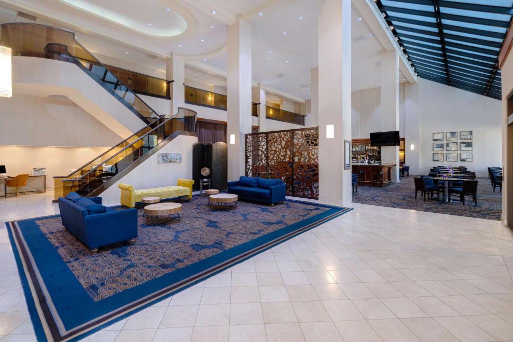 圣克拉拉Embassy Suites by Hilton Santa Clara Silicon Valley的大堂设有蓝色的沙发和楼梯