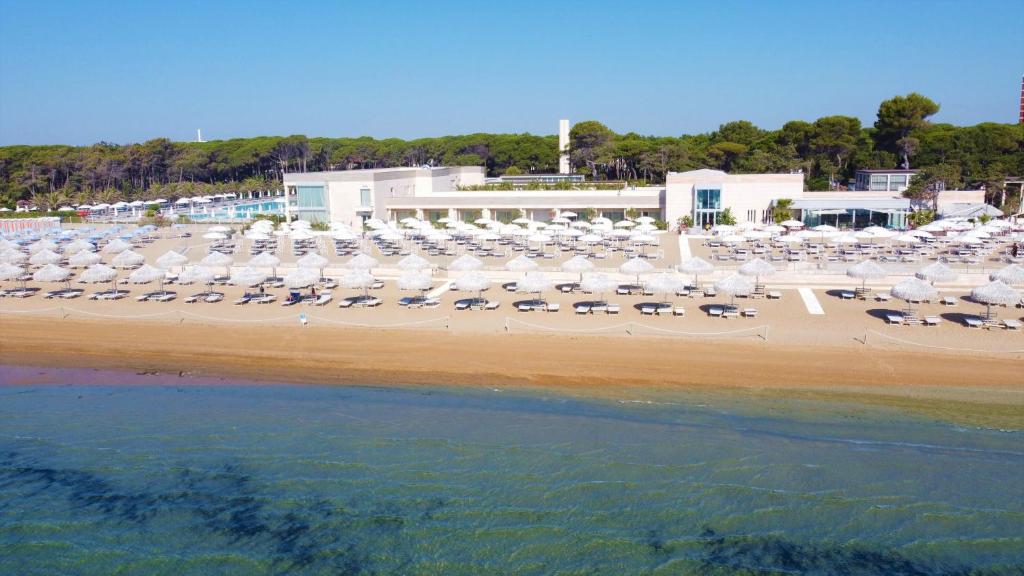 利尼亚诺萨比亚多罗Riviera Resort Hotel的海滩上有很多椅子和遮阳伞