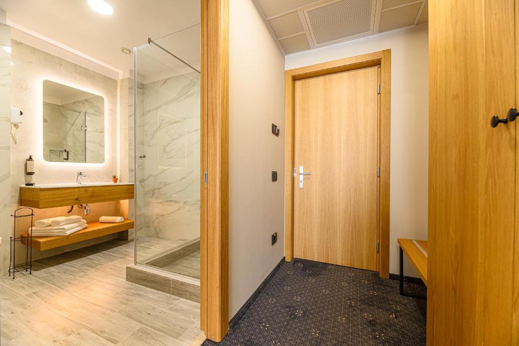 古拉哈莫卢洛伊Hotel DUKAT的一间带步入式淋浴间和玻璃门的浴室