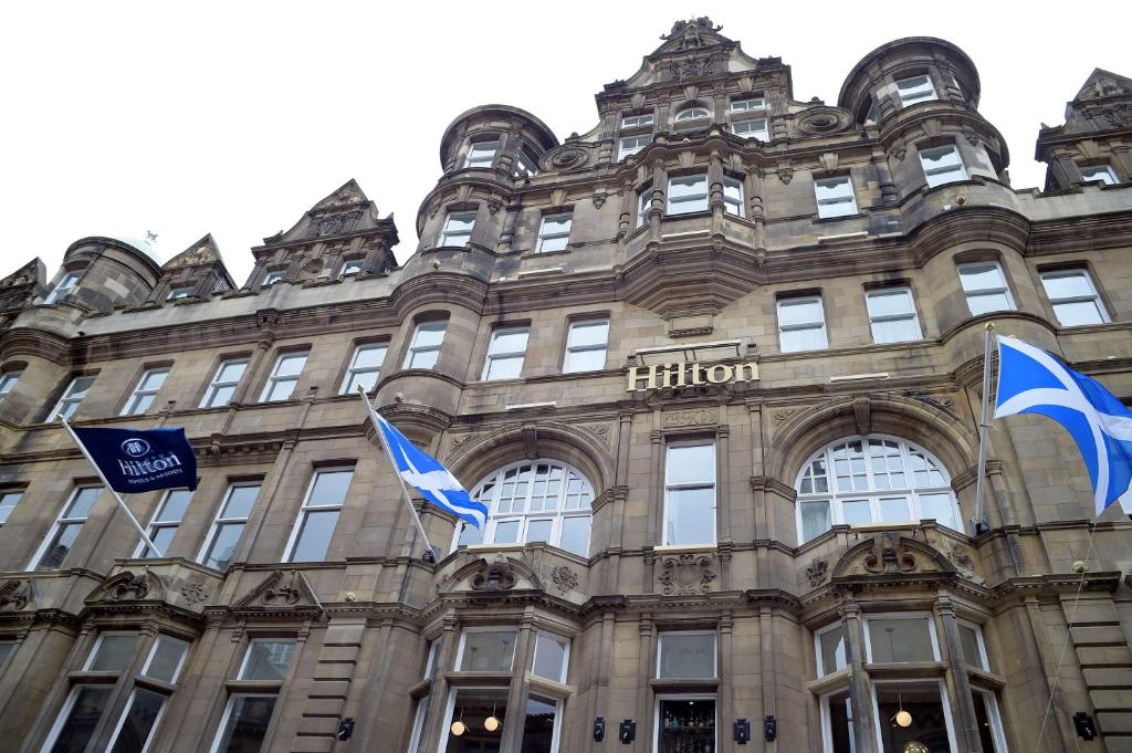 爱丁堡希尔顿爱丁堡卡尔顿酒店的前面有旗帜的建筑
