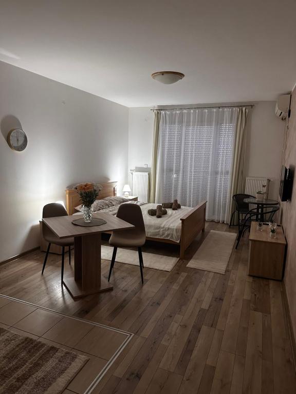 鲁马Apartman San的卧室配有一张床和一张桌子及椅子