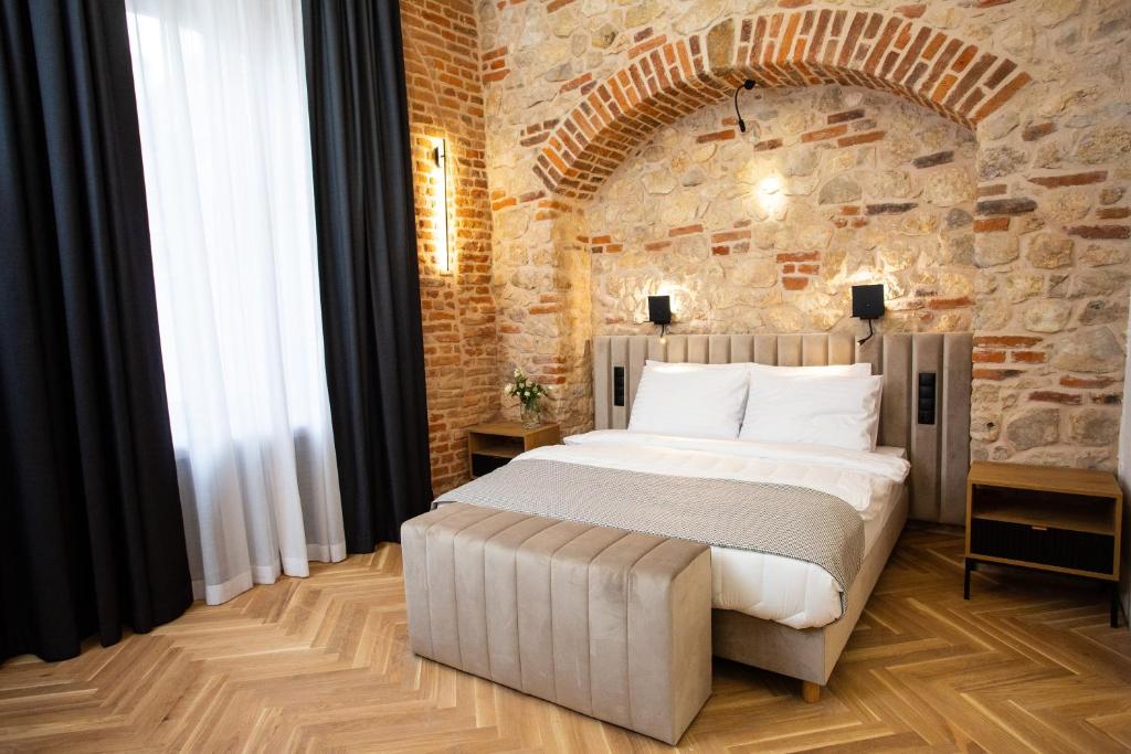 克拉科夫HOTEL TEATR的卧室设有一张砖墙内的大床