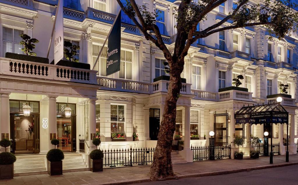 伦敦100 Queen’s Gate Hotel London, Curio Collection by Hilton的前面有一棵树的白色大建筑