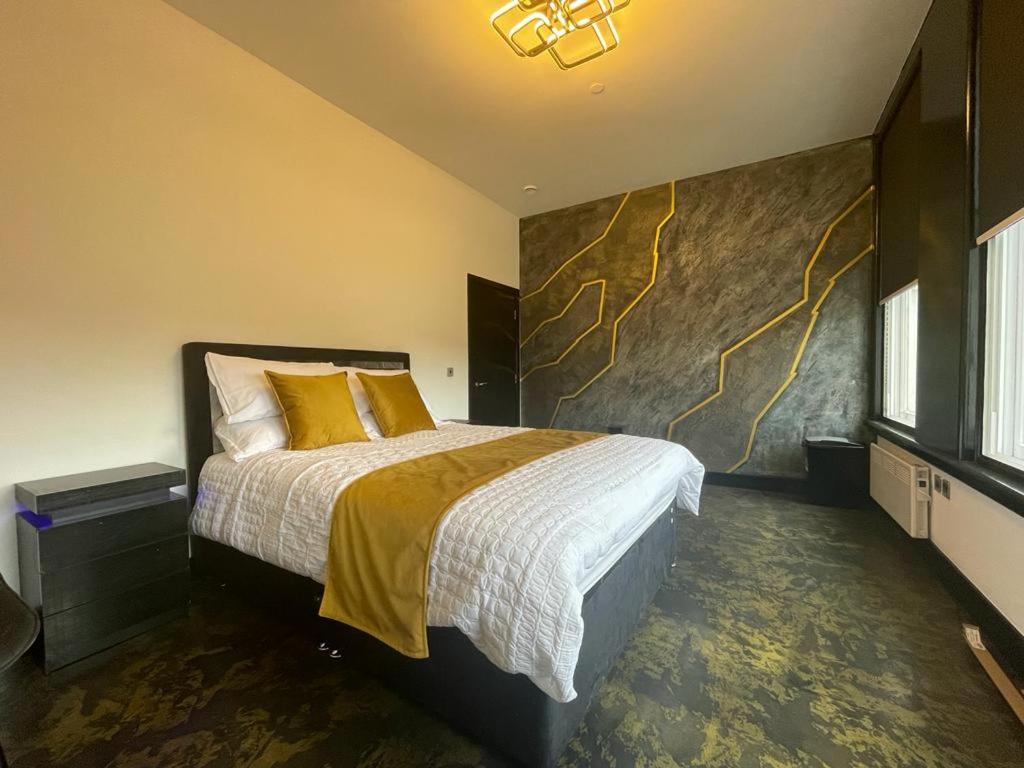 布雷得佛Centenary Apartments的一间卧室配有一张带黄色枕头的大床