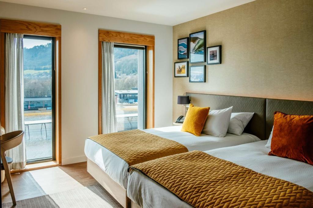 康威Hilton Garden Inn Snowdonia的酒店客房设有两张床和窗户。
