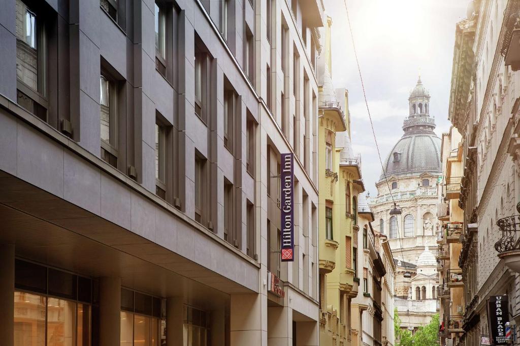 布达佩斯Hilton Garden Inn Budapest City Centre的一条拥有高楼和大教堂的城市街道