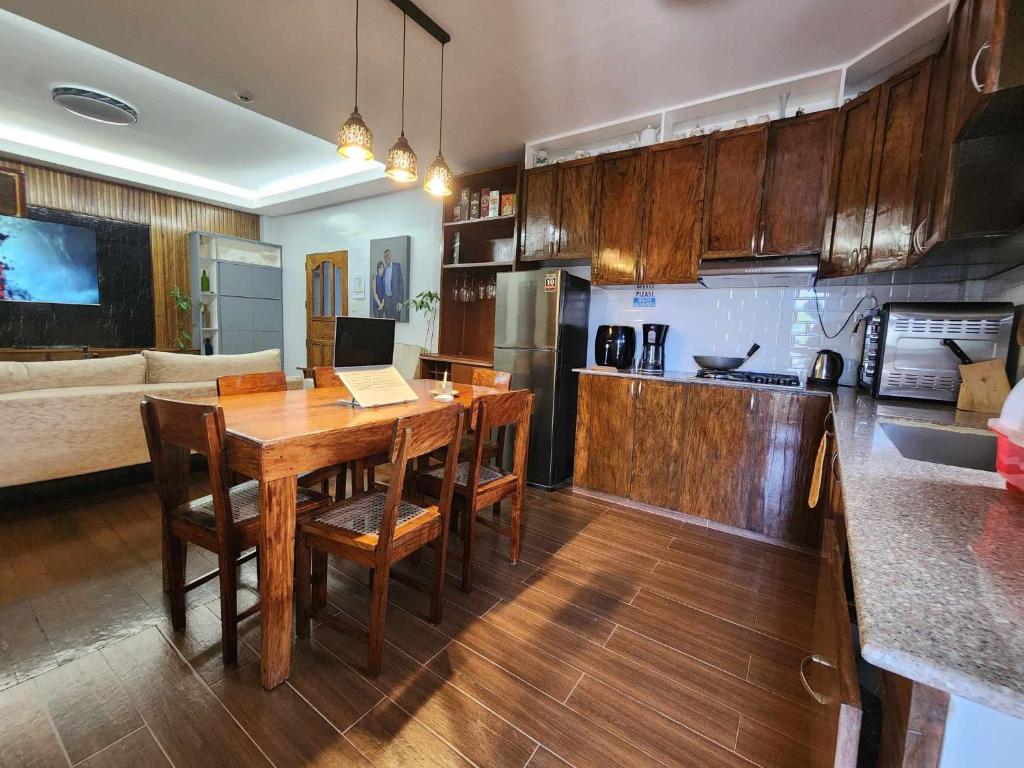 巴斯科Lorenzo's Homestay的厨房以及带木桌和椅子的客厅。