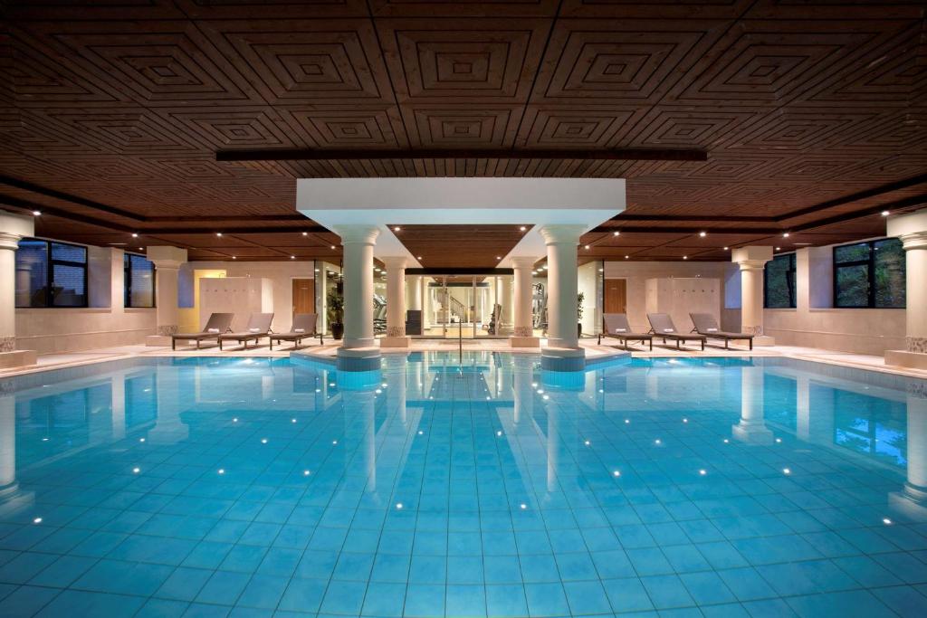 索斯图尼恩DoubleTree by Hilton Royal Parc Soestduinen的大楼内带椅子的大型游泳池