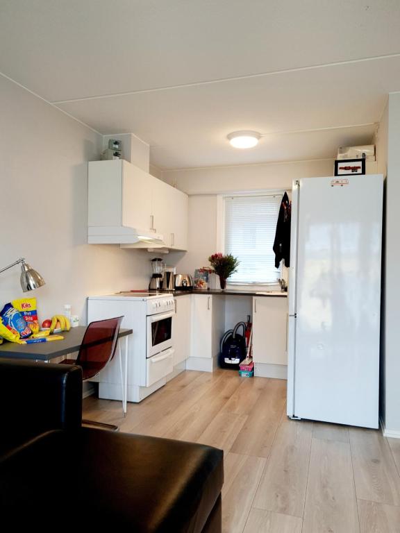 奥斯陆Modern central apartment next to beautiful nature2424的厨房配有白色橱柜和白色冰箱。