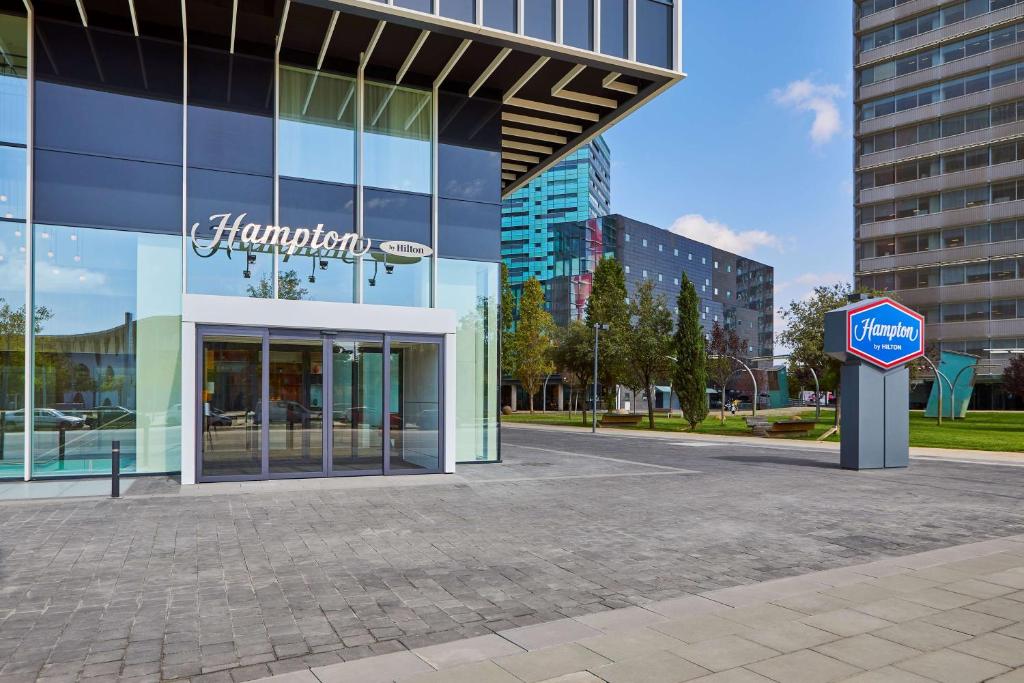 略夫雷加特河畔奥斯皮塔莱特Hampton By Hilton Barcelona Fira Gran Via的前面有药房标志的建筑