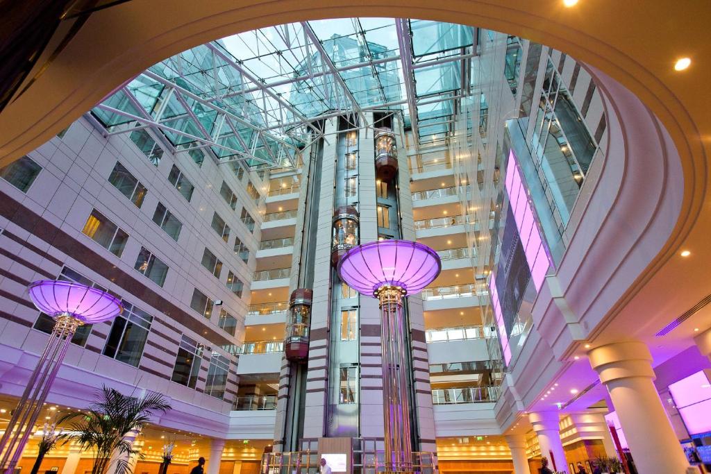 鲁瓦西昂法兰西希尔顿巴黎戴高乐机场酒店的一座带玻璃天花板和紫色灯的大建筑