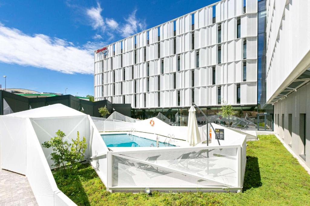 阿尔考本达斯Hampton By Hilton Alcobendas Madrid的大楼前有游泳池的酒店