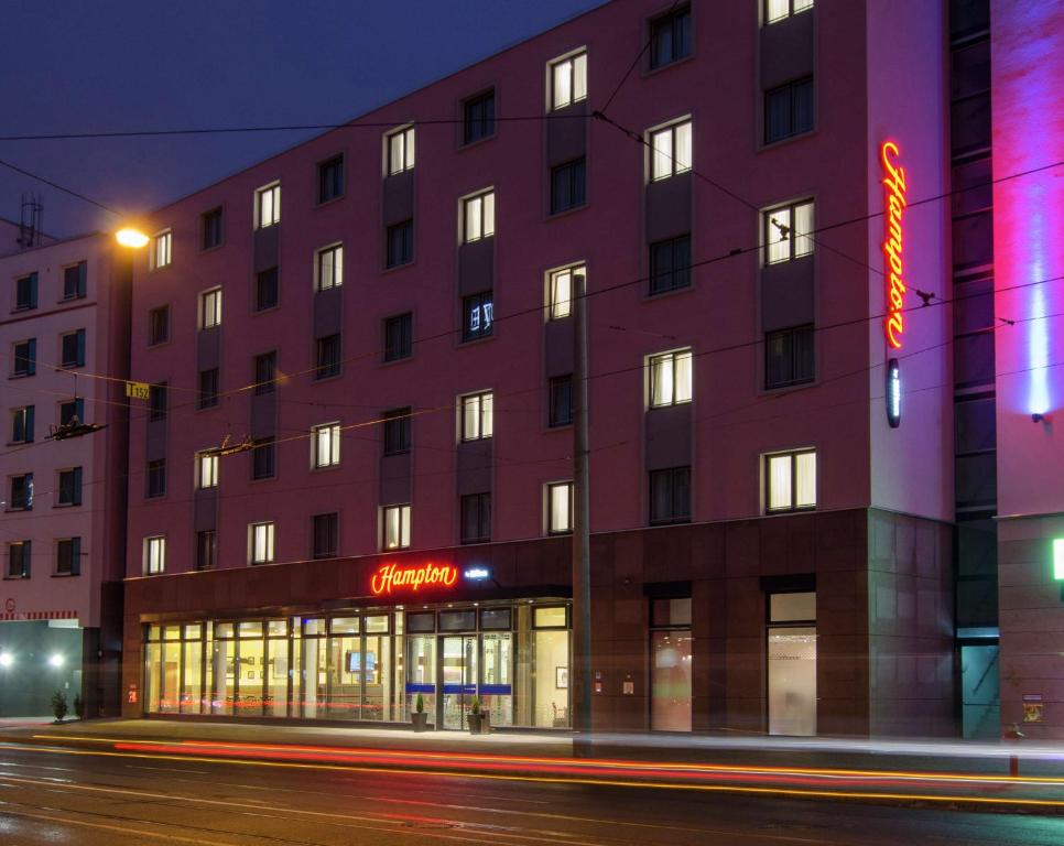 纽伦堡纽伦堡市中心希尔顿汉普顿酒店的前面有 ⁇ 虹灯标志的建筑