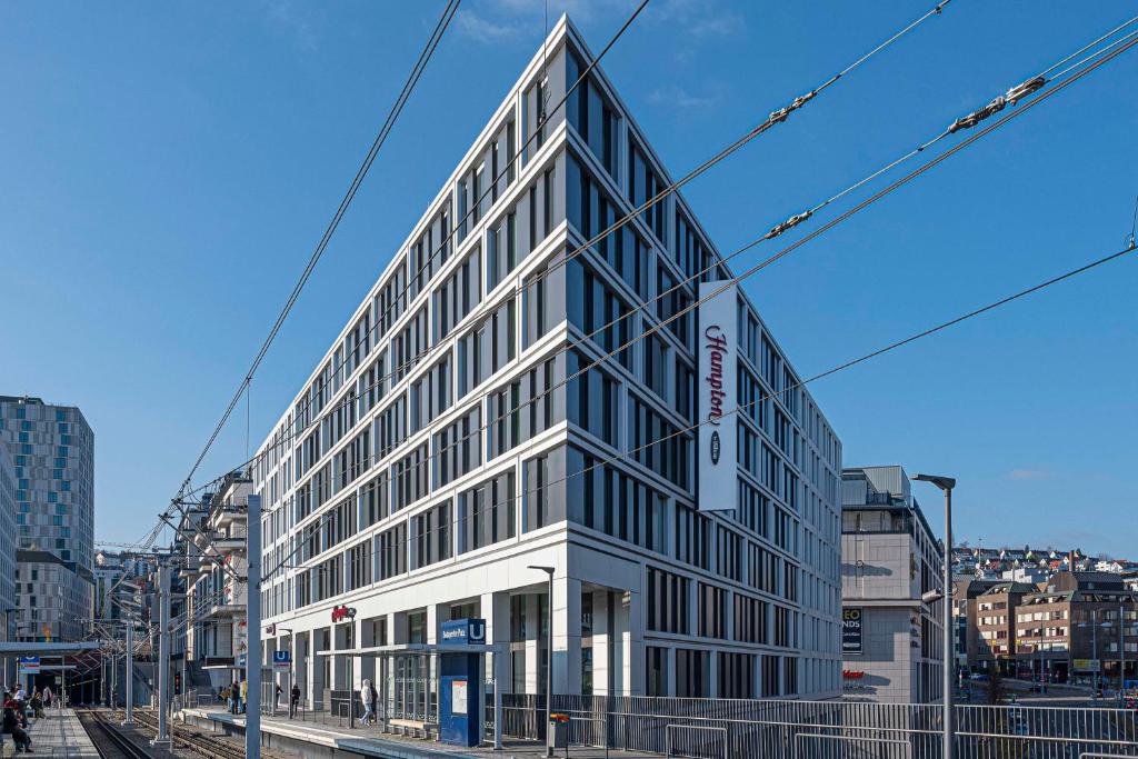 斯图加特Hampton by Hilton Stuttgart City Centre的城市街道上一座高大的玻璃建筑