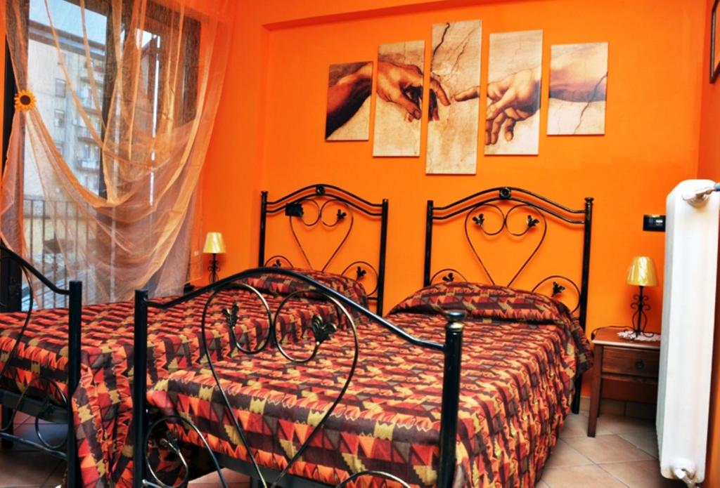阿格里真托太阳与月亮度假屋的一间带两张床的卧室,拥有橙色的墙壁