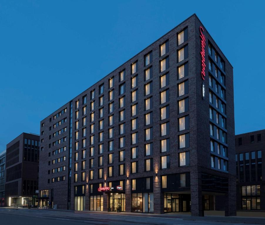 汉堡汉堡市中心希尔顿汉普顿酒店的一座高大的黑色建筑,上面有红色的标志