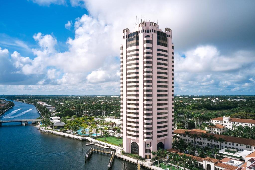 布卡拉顿Tower at The Boca Raton的水体旁的一座高大的白色建筑