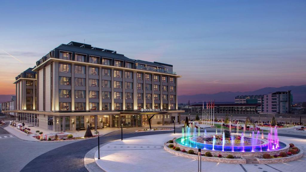 斯科普里DoubleTree By Hilton Skopje的一座大型建筑,前面有一个喷泉