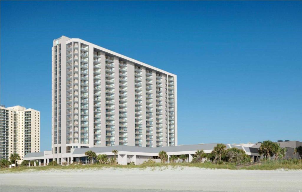默特尔比奇Embassy Suites by Hilton Myrtle Beach Oceanfront Resort的海滩旁的白色大建筑