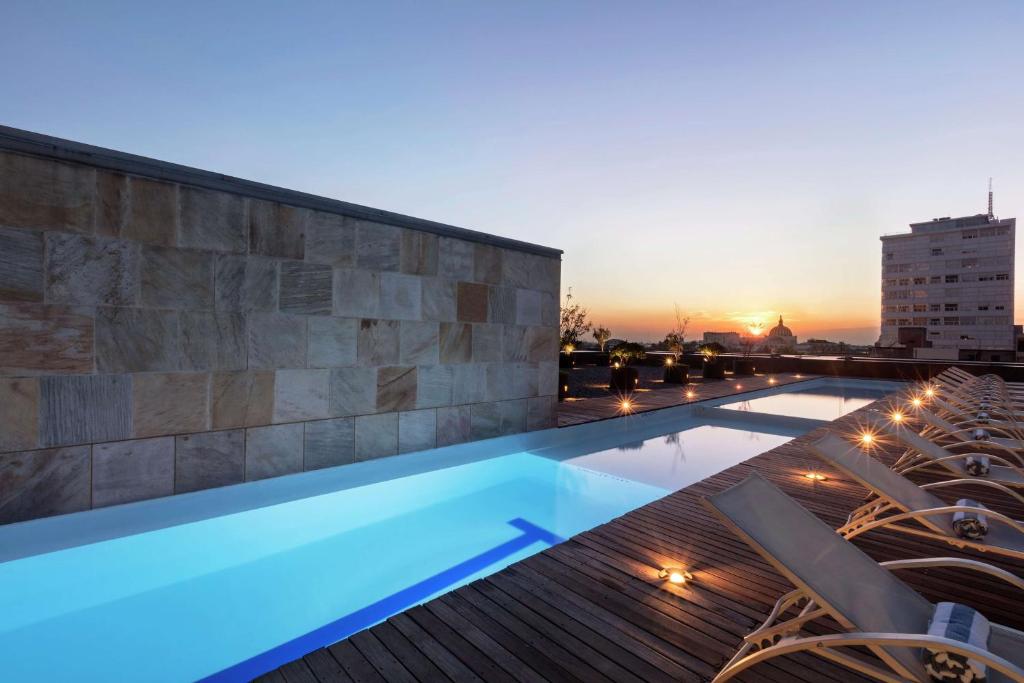 墨西哥城墨西哥城希尔顿改革大道酒店的一座享有日落美景的建筑的顶部游泳池