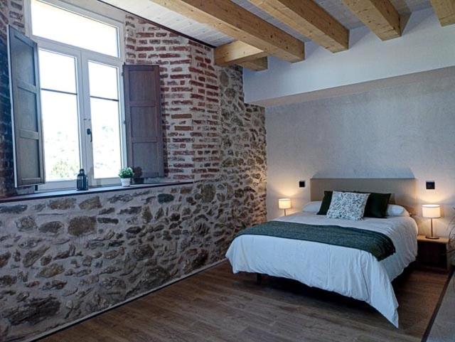 洛索亚河畔布伊特拉戈El Esquileo的一间卧室设有一张床和砖墙