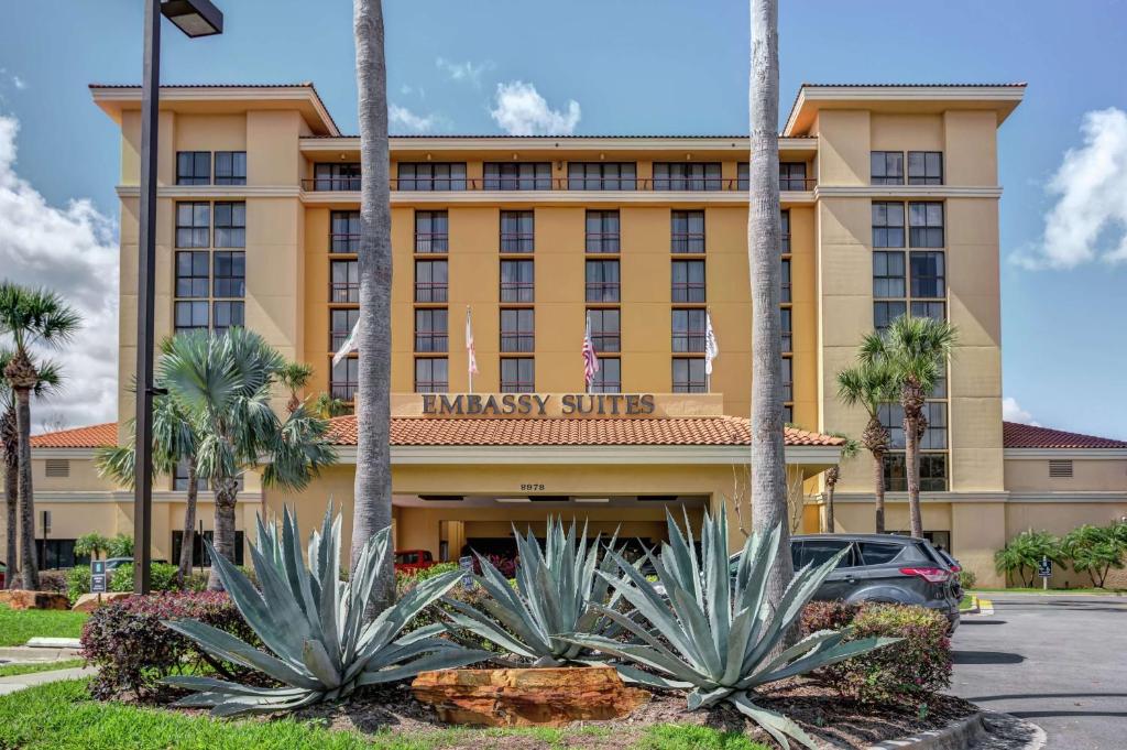奥兰多奥兰多国际大道会展中心希尔顿合博套房酒店的一座酒店大楼前面有棕榈树
