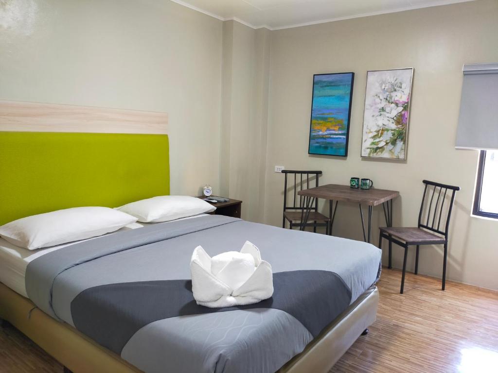 马尼拉塞勒姆DG经济型酒店的卧室配有一张床和一张桌子及椅子