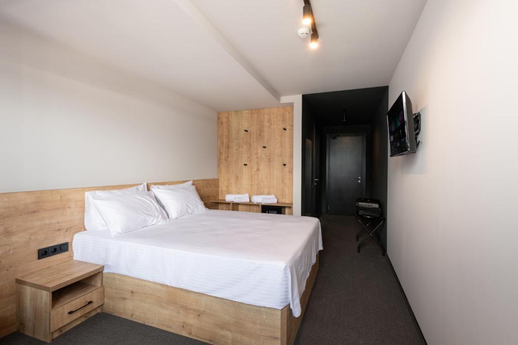 巴统BET25 Hotel的卧室配有一张白色大床和电视。