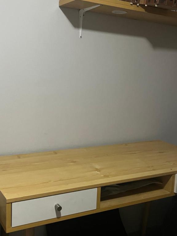 巴兰卡Alójate en una Casa familiar的一张木制桌子,靠着白色的墙壁,配有抽屉