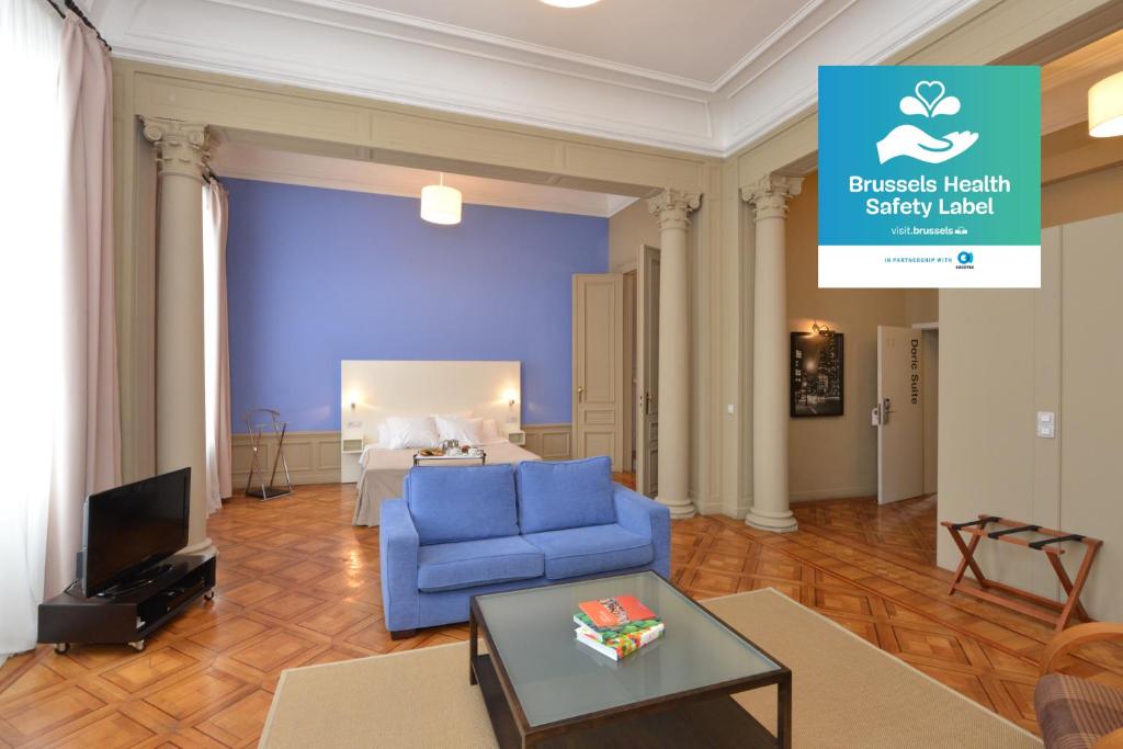 布鲁塞尔MAS Aparthotel EU的客厅配有蓝色的沙发和床。