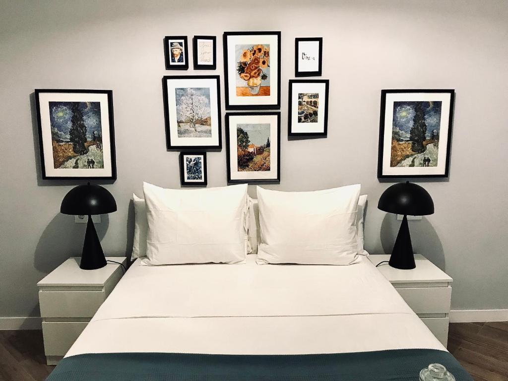 梅里达Apartamentos Élite - Art Collection - Vincent的卧室配有一张白色床,墙上挂有框图