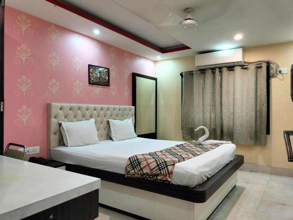 加尔各答Hotel Sweet Dream的一间卧室设有一张床和粉红色的墙壁