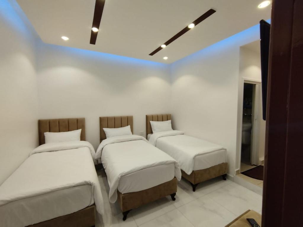 瓦迪穆萨穆萨温泉大酒店 的白色墙壁的客房内的三张床