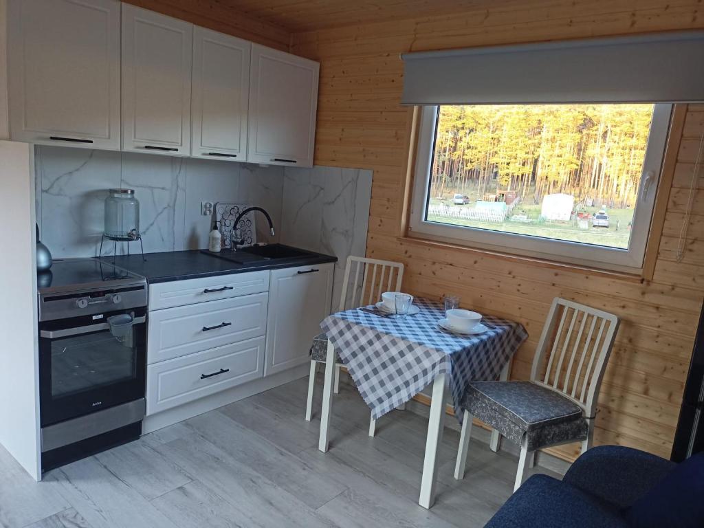 LeśnoOsada Rolbik的厨房配有桌椅和窗户。