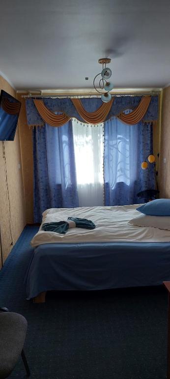 斯特雷Гостьові квартири Геолог的一间卧室配有一张带蓝色窗帘的大床