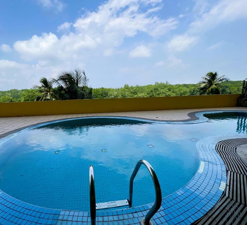 卢穆特Dindings Pantai Desair Apartment By DPD的度假村内的一个蓝色海水游泳池