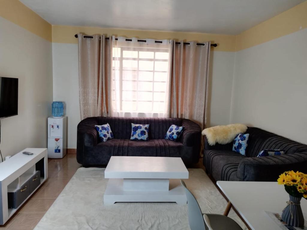 思由基茅Grey Homes, 2 bedroom apartments along mombasa road, near JKIA & SGR Nairobi的客厅配有沙发和桌子