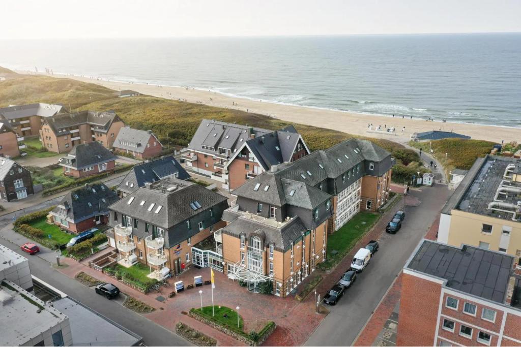 韦斯特兰Strandhotel Sylt GmbH的海滩旁房屋的空中景致