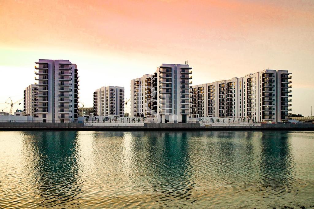 阿布扎比Sea World Yas Island Luxury Holiday Apartment 915的一群高大的建筑,靠近水体