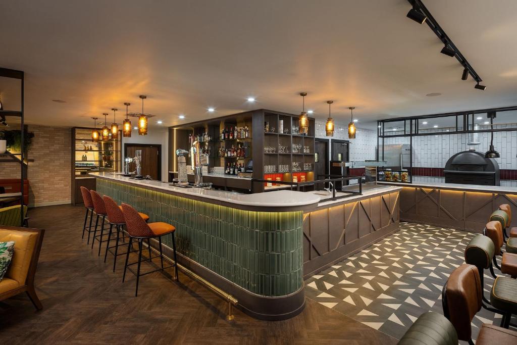 爱丁堡干草市场先瑞酒店的一间设有橙色椅子的餐厅酒吧