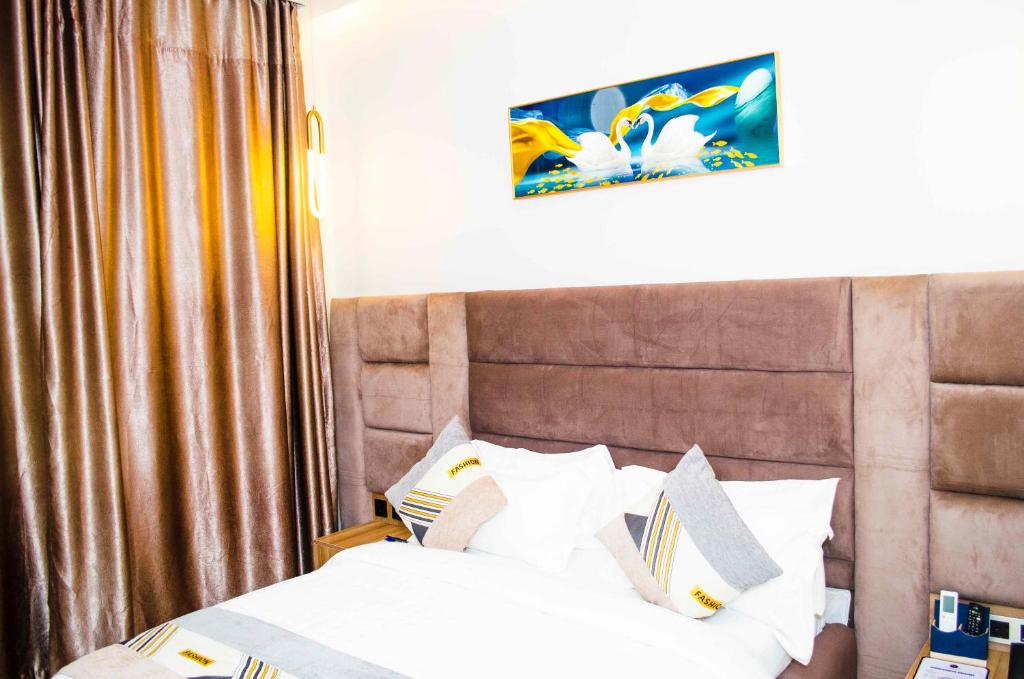 JiduOzinny Signatures Hotel的一间卧室配有带白色床单和枕头的床。