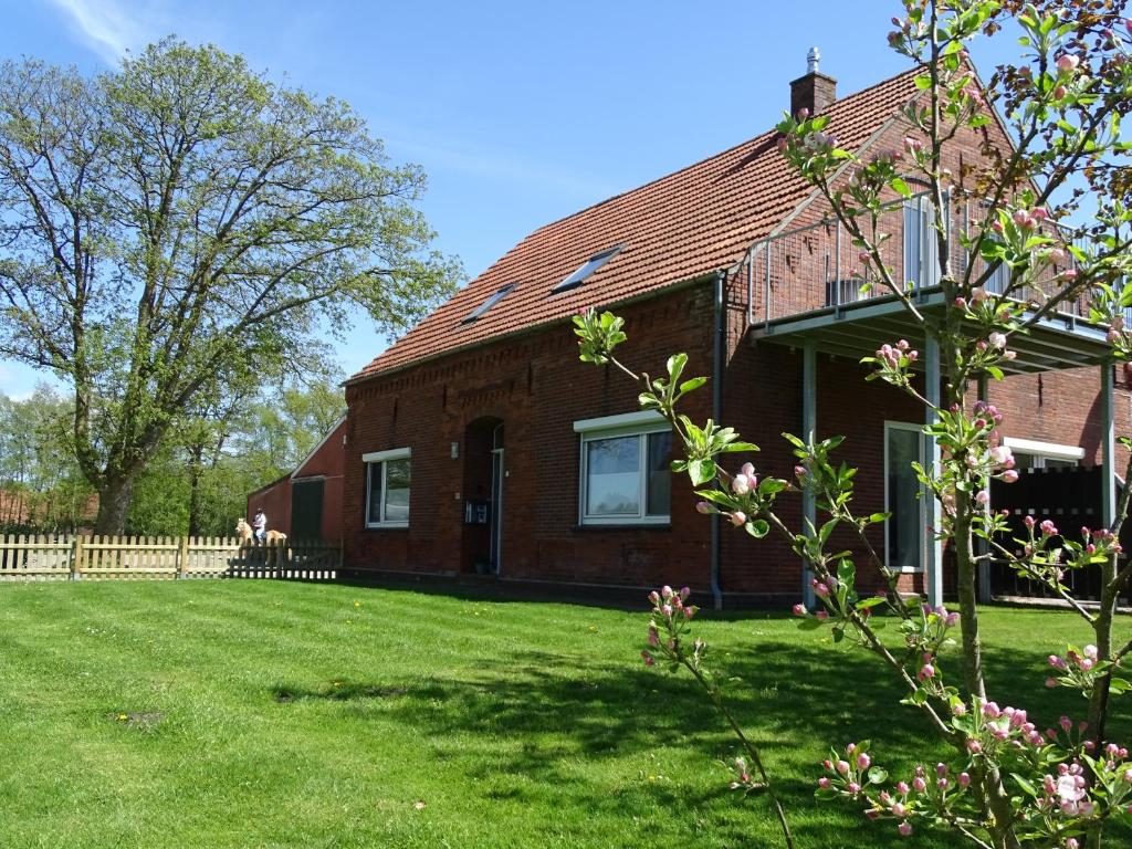 ArleFerienhof Ostarle的绿色庭院的红砖房子