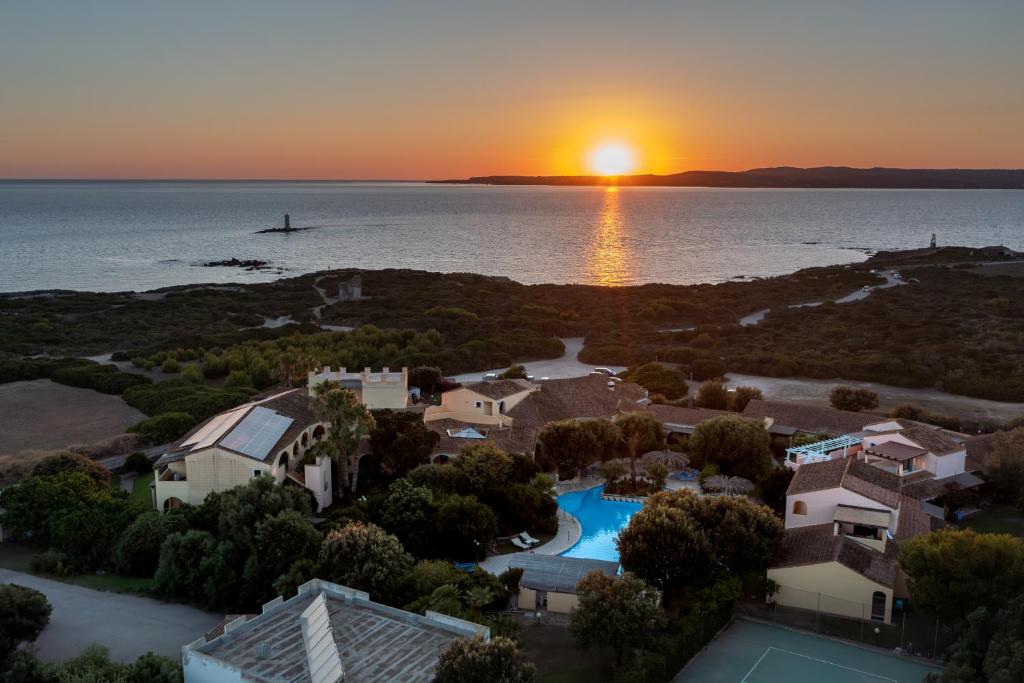 卡拉赛达露其德尔法罗酒店的日落时分享有房子和海洋的空中景致