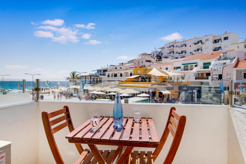 卡武埃鲁Hotel Carvoeiro Plaza的海滩景阳台配有桌椅