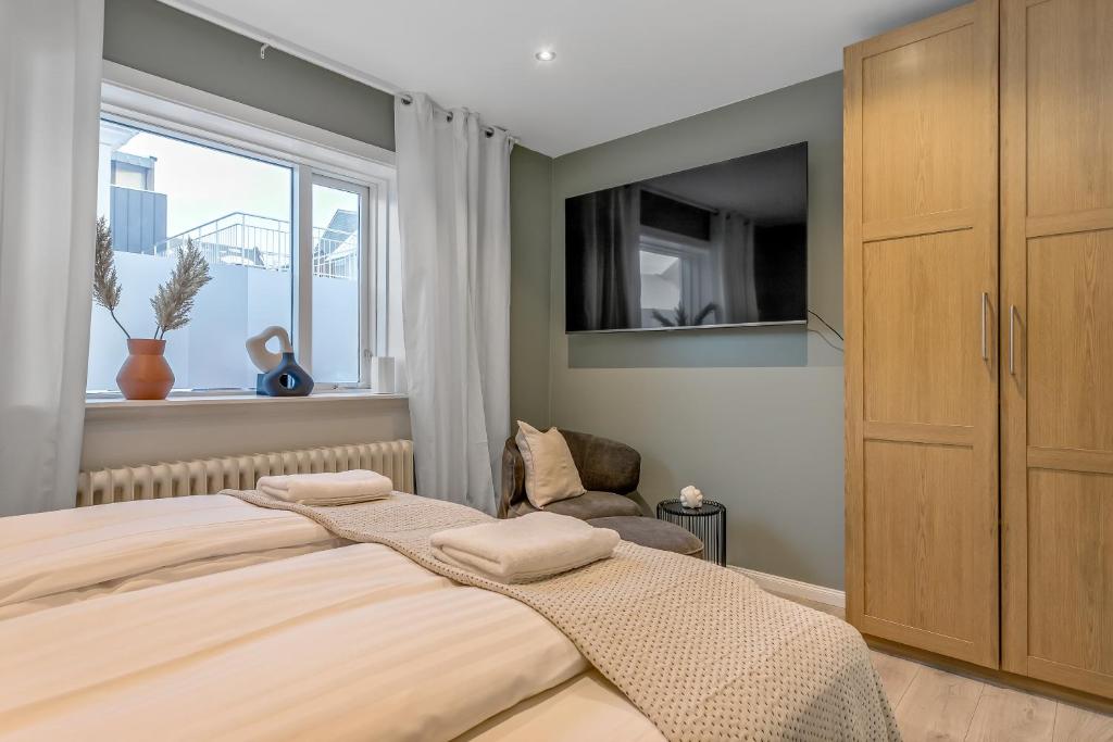 雷克雅未克Venture Vacation-Reykjavík Center, King bed, 65" TV with Netflix的一间卧室设有一张大床和一个窗户。
