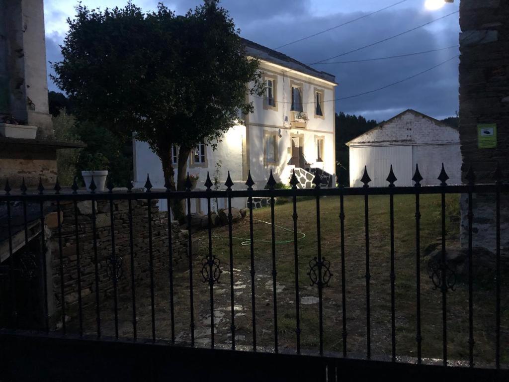 福斯Casa de Campo Pumarada de Oirín的白色房子前面的黑色围栏
