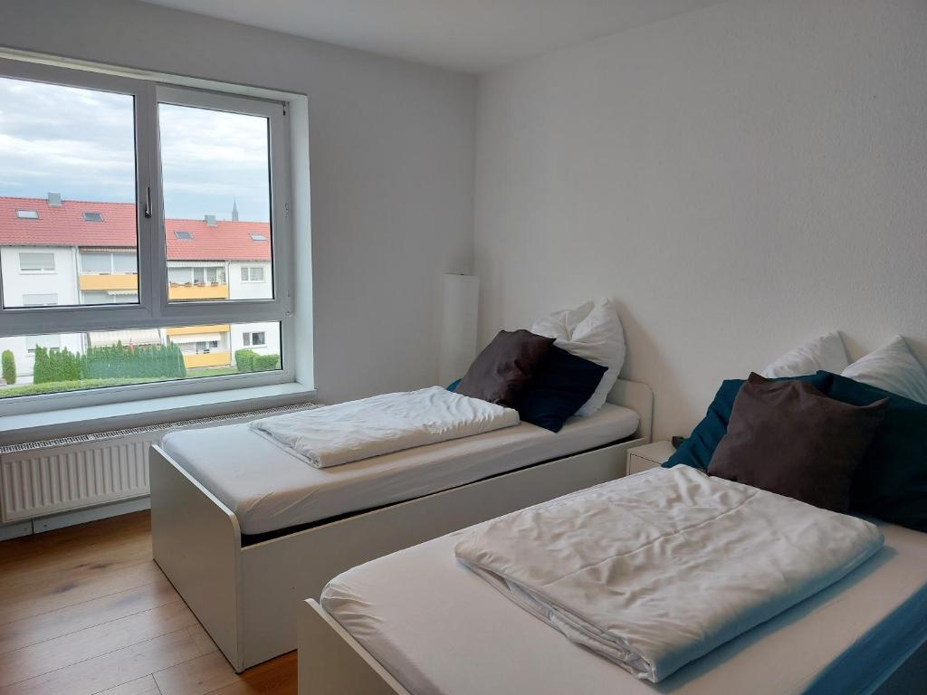 乌尔姆Rooftop Apartments - Doppelzimmer in Gemeinschaftsunterkunft (Weinberg R2)的带窗户的客房内的两张床