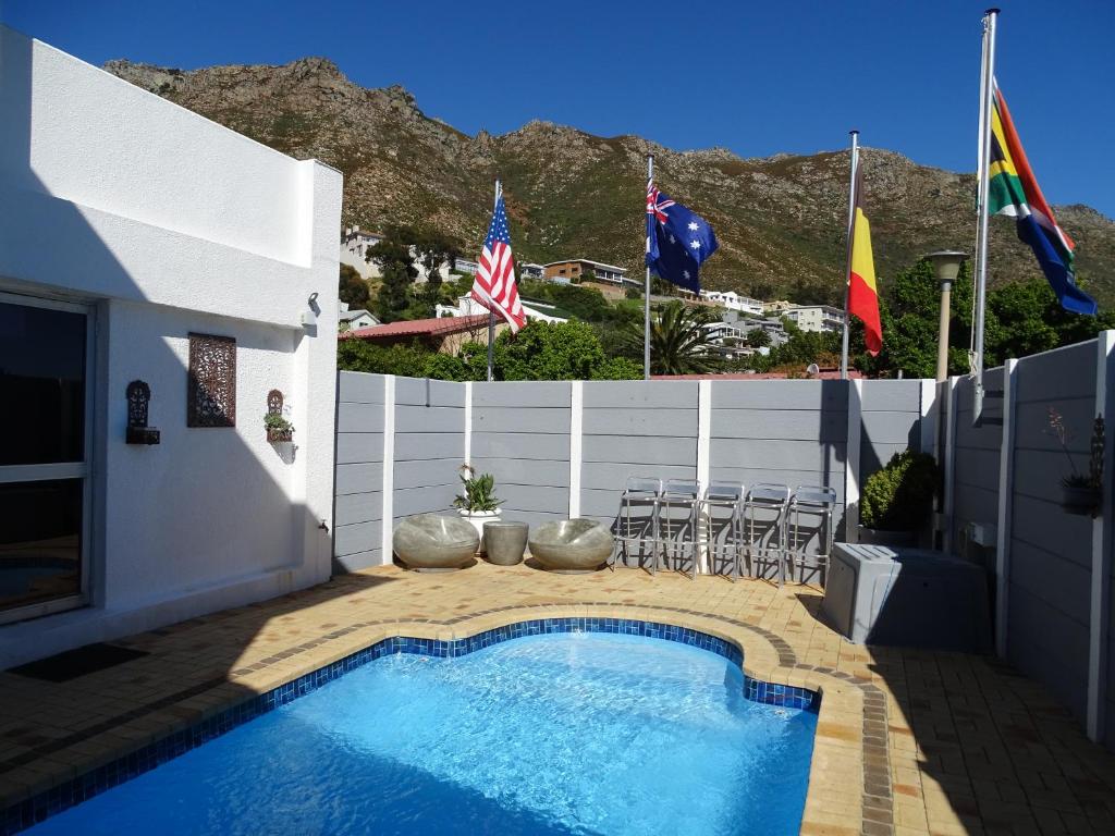 戈登湾Big Skies Guesthouse的靠近带旗帜的围栏的游泳池