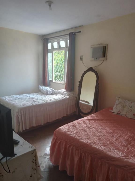 维多利亚Hostel Leonardo的客房设有两张床、镜子和电视。